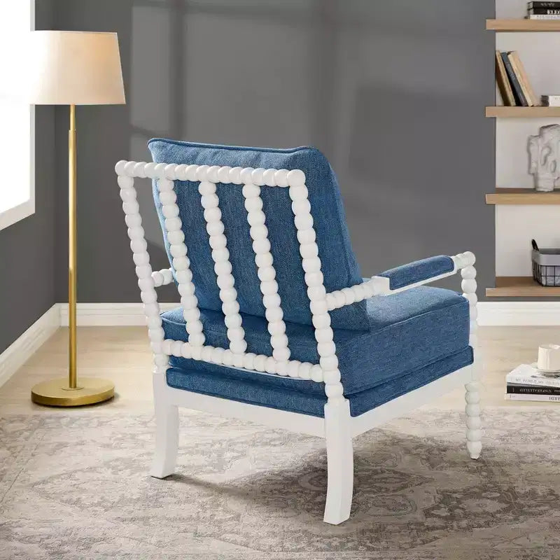 Sillón auxiliar tapizado Spool con estructura de madera torneada